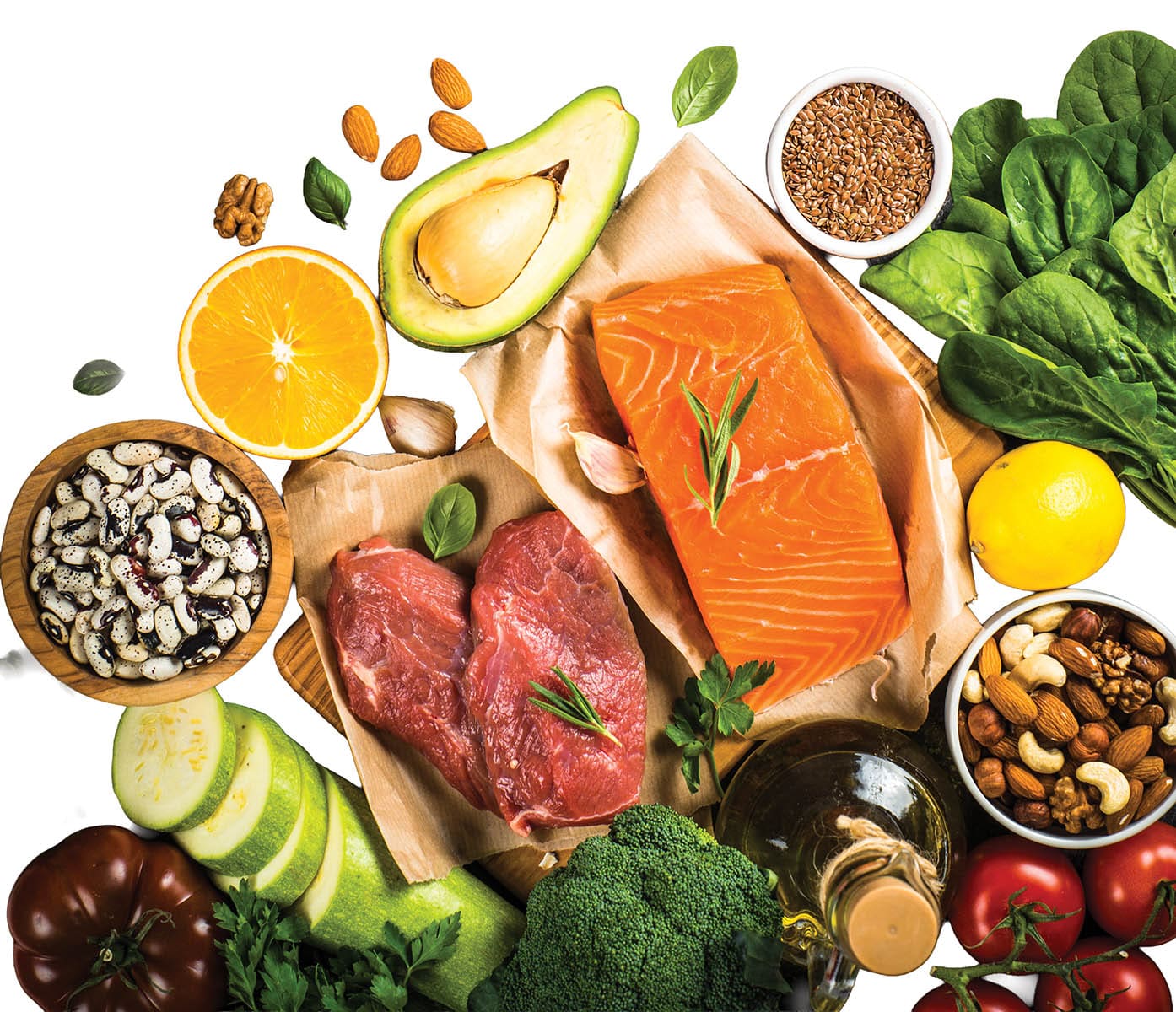 Keto diet food. Healthy food products at black background. Salmon steak, beef, beans, nuts, vegetables and olive oil. Top view image at black stone table.